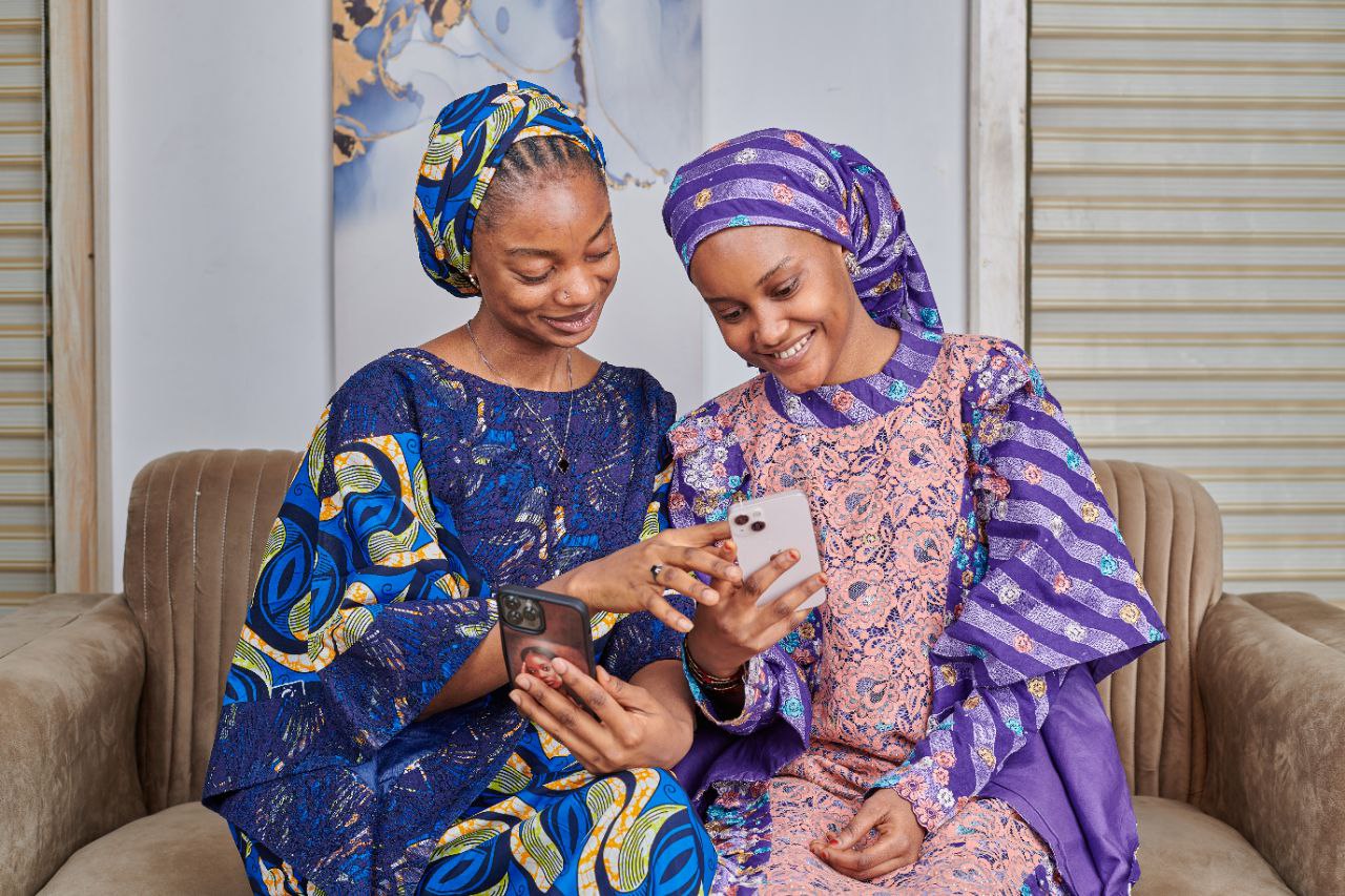 Two women working with phones showing financial independence
